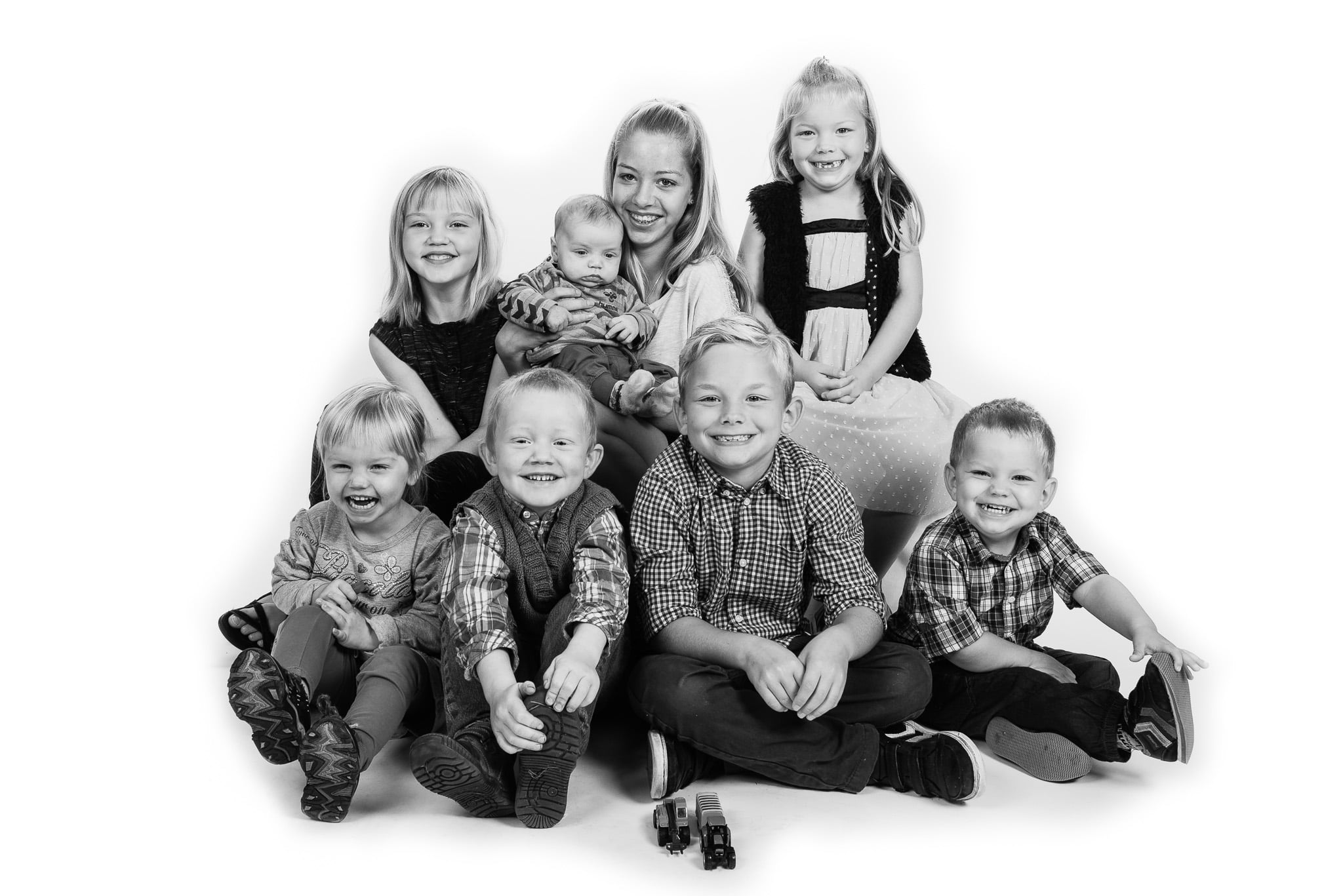 Sort-hvid gruppebillede af 8 grinende børn